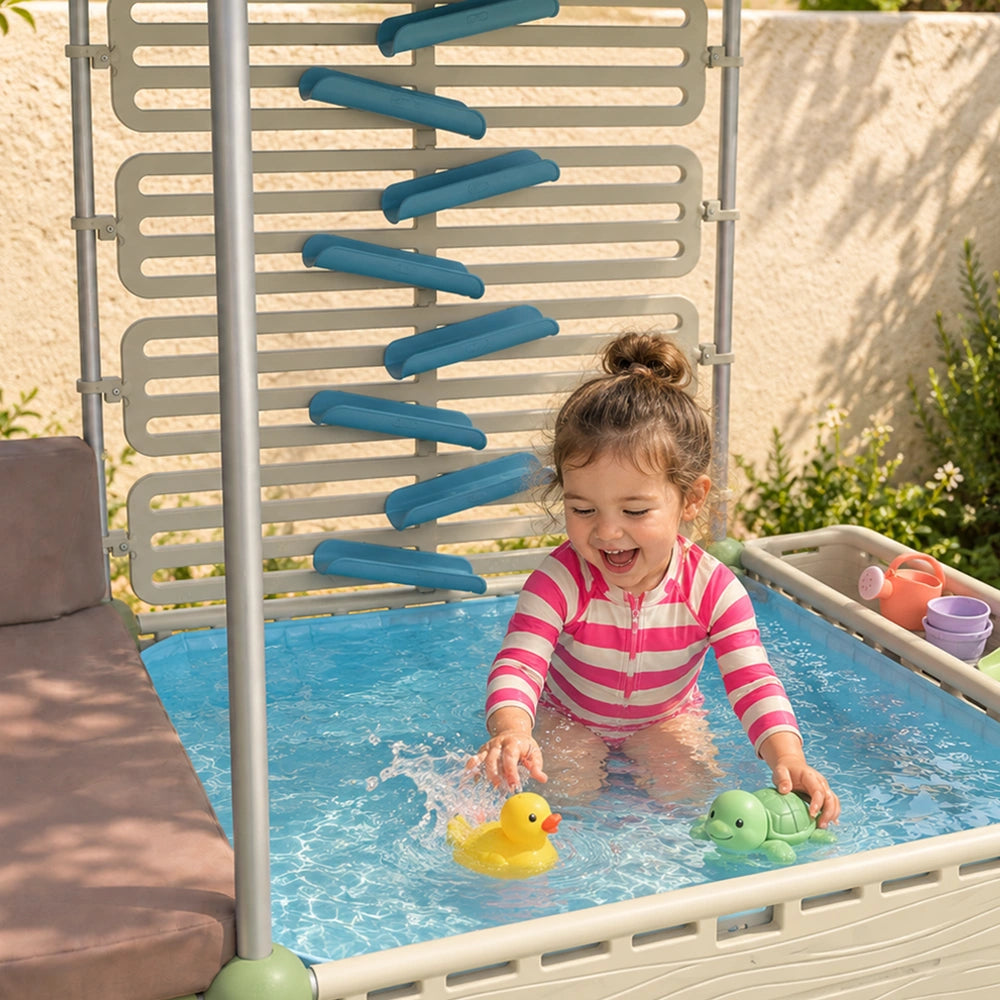 Toddler splashing in The Lagoon paddling pool beside the water chute wall