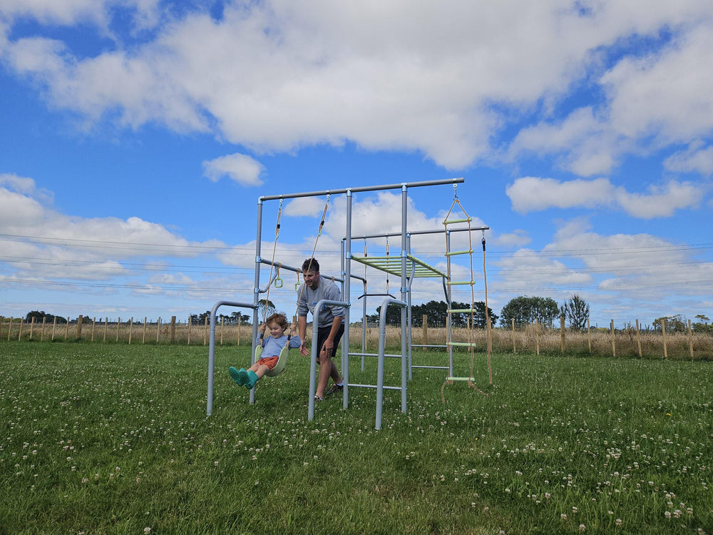 Kids playing on a green metal swing set in Australia