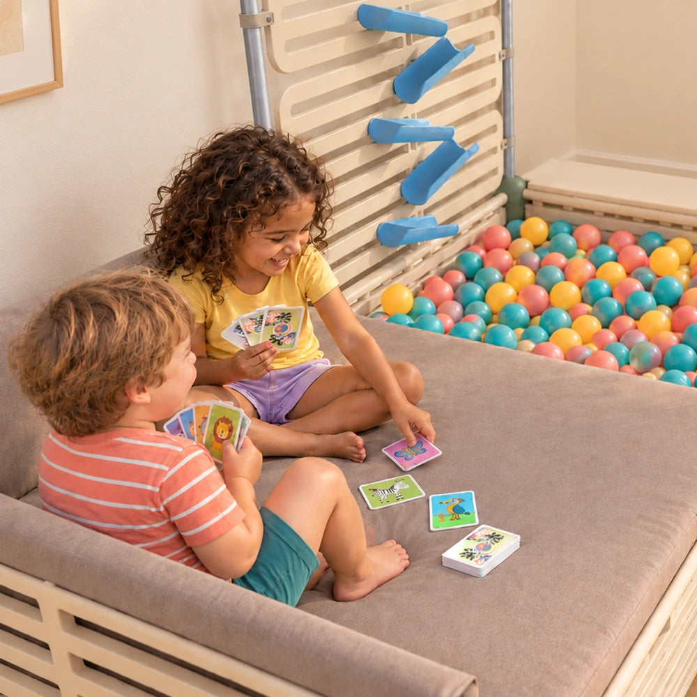 Two children playing cards on The Cabana day bed